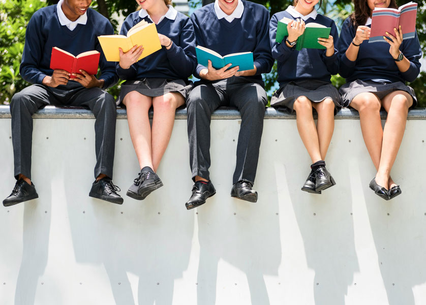 Choiss Coaching, students sitting on a wall reading books